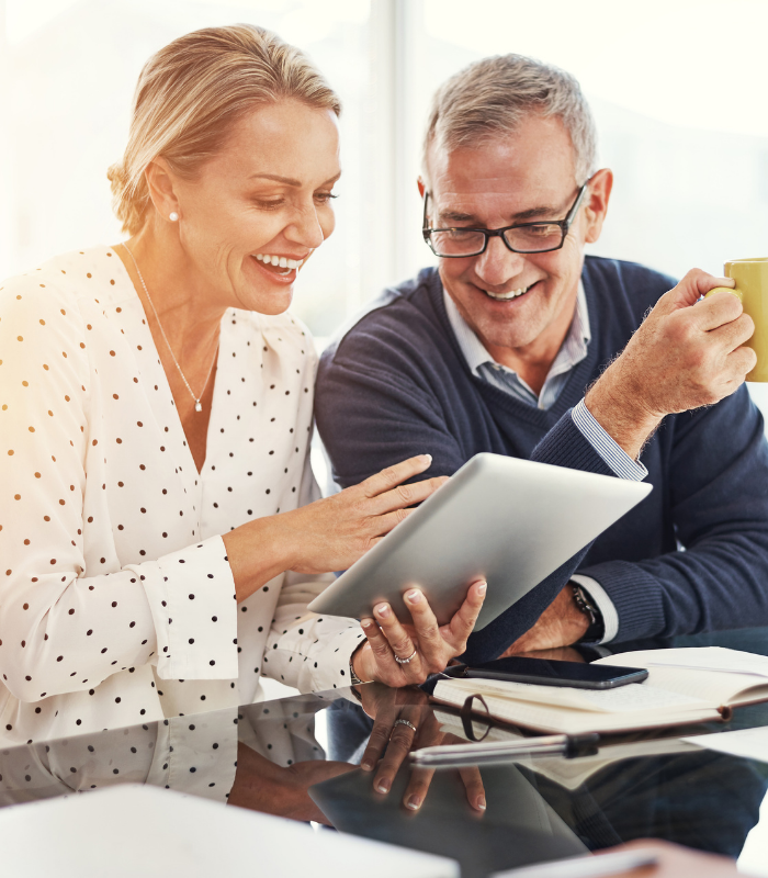 5 man and women looking at tablet and smiling